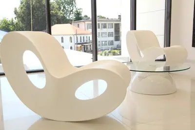 a white chair and table in a room with windows at Zepter Hotel in Bosanska Dubica