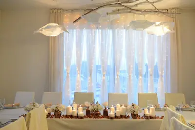 a table with candles in front of a large window at Zepter Hotel in Bosanska Dubica