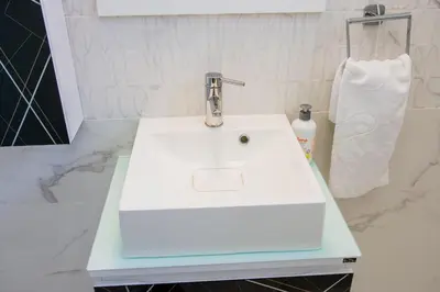 a white sink in a bathroom with a towel at Grande Plus Apartment Dzungla in Doboj