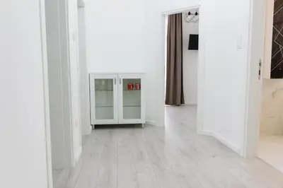 an empty room with white walls and wooden floors at Grande Plus Apartment Dzungla in Doboj