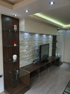 a living room with a television and a brick wall at Apartman Marković in Bosanski Šamac