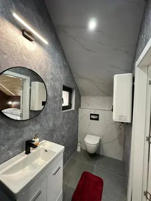 a bathroom with a sink and a toilet and a mirror at Apartments MLIN in Bihać