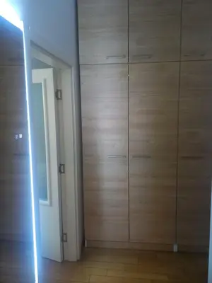 a room with a wall of wooden cabinets at NM apartman in Banja Luka