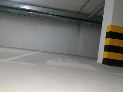 an empty parking garage with a yellow and white wall at NM apartman in Banja Luka