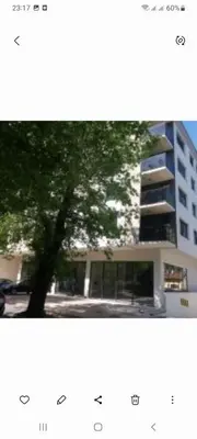a picture of a tree in front of a building at NM apartman in Banja Luka