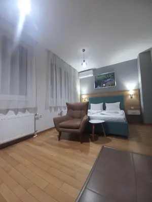 a hotel room with a bed and a chair at NM apartman in Banja Luka