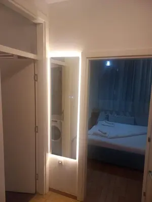 a room with a bed and a door with a mirror at NM apartman in Banja Luka