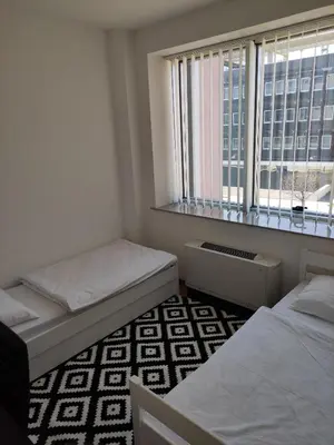 two beds in a room with a window at Apartment Dajak Centar in Banja Luka