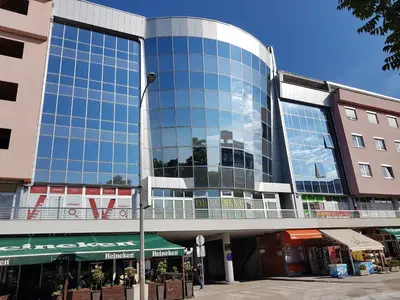 a tall building with a glass facade on a street at Apartment Dajak Centar in Banja Luka