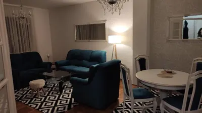 a living room with blue chairs and a table at Apartment Dajak Centar in Banja Luka