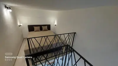 a small bedroom with a bed in a white wall at Studio Apartman Malkoc in Bihać