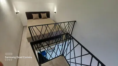 a room with a bed on top of a staircase at Studio Apartman Malkoc in Bihać