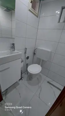 a white bathroom with a toilet and a sink at Studio Apartman Malkoc in Bihać