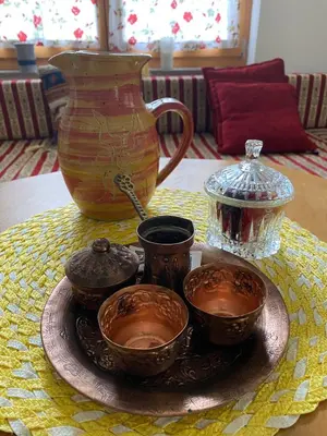 a plate with four cups and a vase on a table at Atlantis Home in Kulen Vakuf