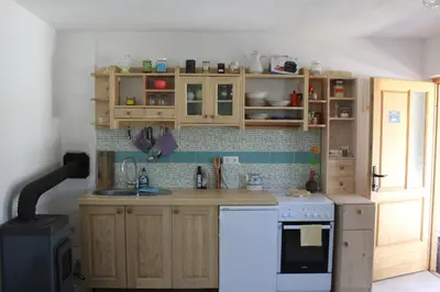 a kitchen with wooden cabinets and a white stove top oven at Atlantis Home in Kulen Vakuf