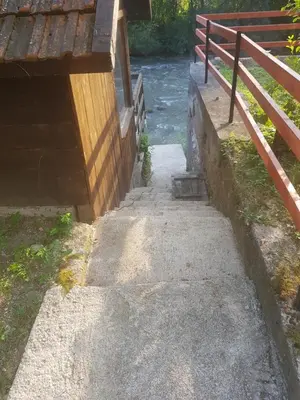 a stairway leading down to a river next to a fence at Sam guest house in Jajce