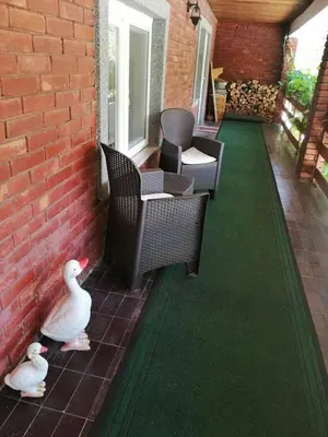 two ducks on a patio with chairs and a brick wall at Sam guest house in Jajce