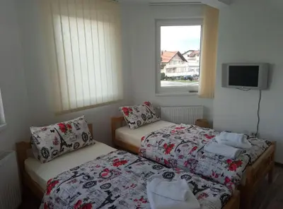 two beds in a small room with a window at Apartments&Rooms Mido in Visoko