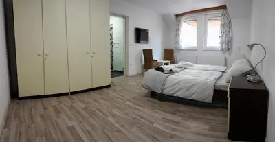 a bedroom with a bed and a desk and a window at Apartments&Rooms Mido in Visoko