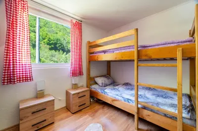 a bedroom with two bunk beds and a window at Domacinstvo na kraju svijeta in Šipovo