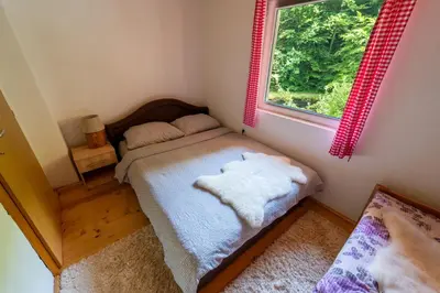 a small bedroom with a bed and a window at Domacinstvo na kraju svijeta in Šipovo
