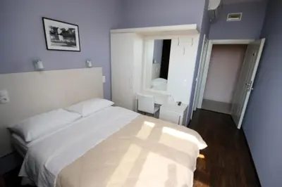 a bedroom with a white bed and a window at Hotel Le Pont in Prijedor