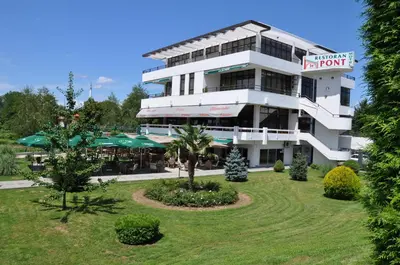 a large white building with a restaurant at Hotel Le Pont in Prijedor