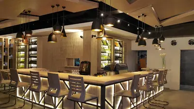 a bar with chairs and a large island in a room at Hotel Le Pont in Prijedor
