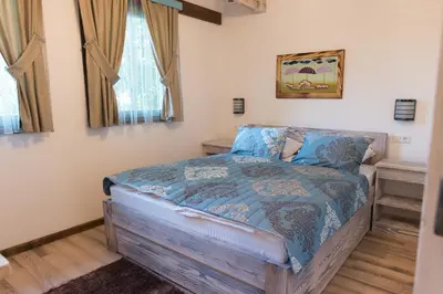 a bedroom with a bed with a blue comforter at Etno Village Cardaci in Vitez