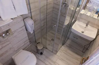 a bathroom with a shower and a toilet and a sink at Etno Village Cardaci in Vitez