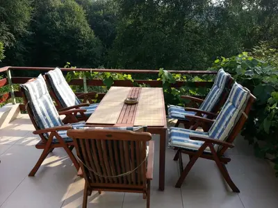 a wooden table and four chairs on a patio at Green Paradise in Visoko