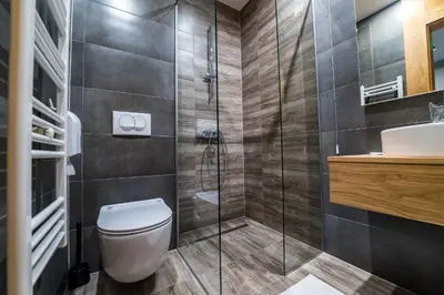 a bathroom with a toilet and a glass shower at Hotel Safir in Bihać