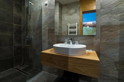 a bathroom with a sink and a shower and a mirror at Hotel Safir in Bihać