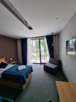 a hotel room with a bed and a chair at Hotel Safir in Bihać