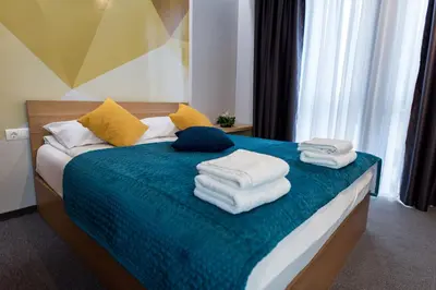 a bedroom with a bed with towels on it at Hotel Safir in Bihać