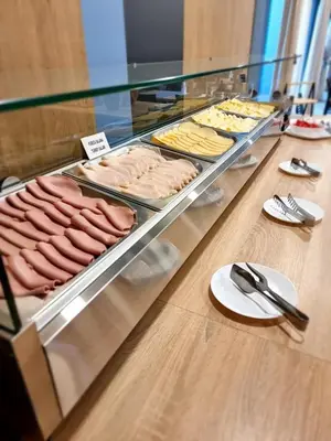 a display case with a bunch of meats and other foods at Hotel Safir in Bihać