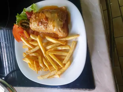 a plate of food with french fries and meat at Apartman Nik-Rom in Bosanska Gradiška