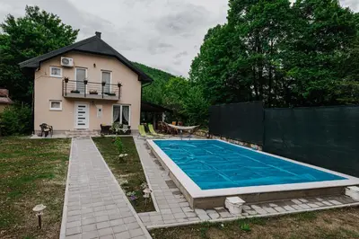 a swimming pool in a yard next to a house at Apartman Ena in Bihać