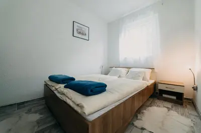 a bedroom with a bed with blue pillows on it at Apartman Ena in Bihać