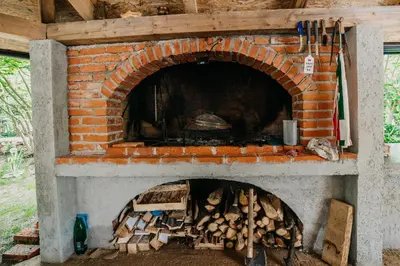 a brick oven with a pile of fire wood at Apartman Ena in Bihać