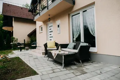a patio with two chairs and a table and a window at Apartman Ena in Bihać