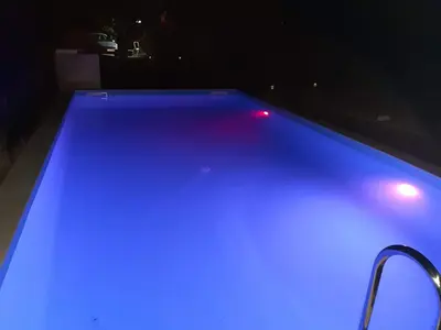 a swimming pool with blue lights in a dark room at Apartman Ena in Bihać