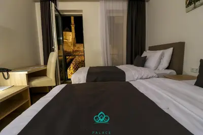 two beds in a hotel room with a hotel rule logo on them at Hotel Vezir Palace in Travnik