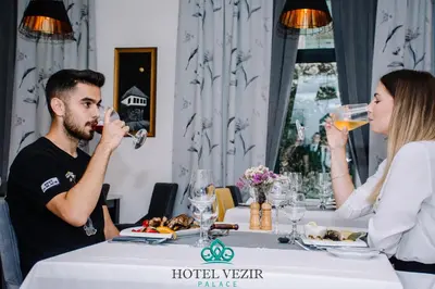 a man and woman sitting at a table drinking wine at Hotel Vezir Palace in Travnik