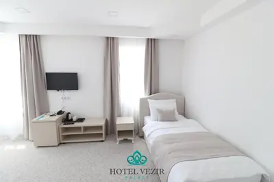a hotel room with two beds and a desk at Hotel Vezir Palace in Travnik