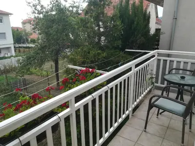 a balcony with a table and chairs and flowers at Apartman Lidija in Livno