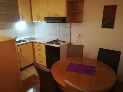 a kitchen with a table and a stove and a sink at Apartman Lidija in Livno