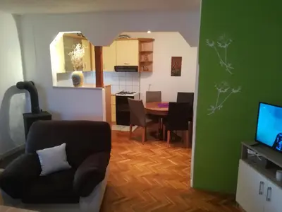 a living room with a chair and a dining room at Apartman Lidija in Livno