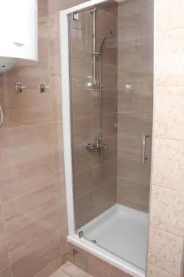a shower with a glass door in a bathroom at Magnolija in Banja Luka