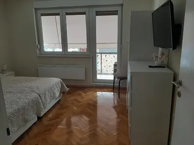 a bedroom with a bed and a dresser with a television at Magnolija in Banja Luka